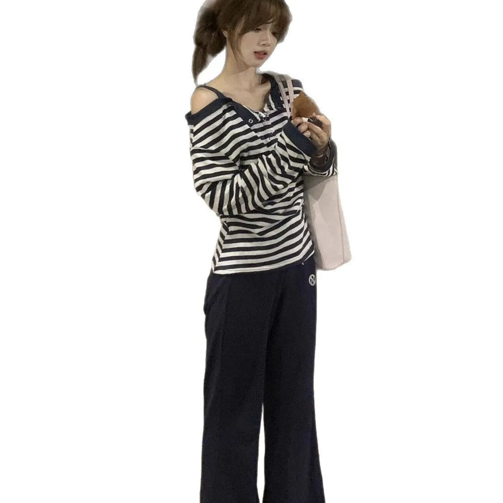 Dark blue women's oversized long-sleeved t-shirt with embroidery and stripe details on a hanger.