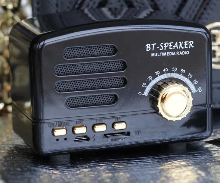 Compact vintage-style wood grain finish Bluetooth speaker on a wooden table.