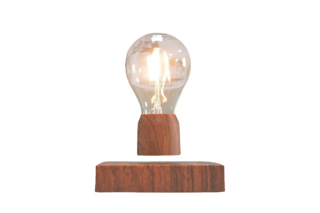 Magnetic levitation floating light bulb with imitation wood base on a table.