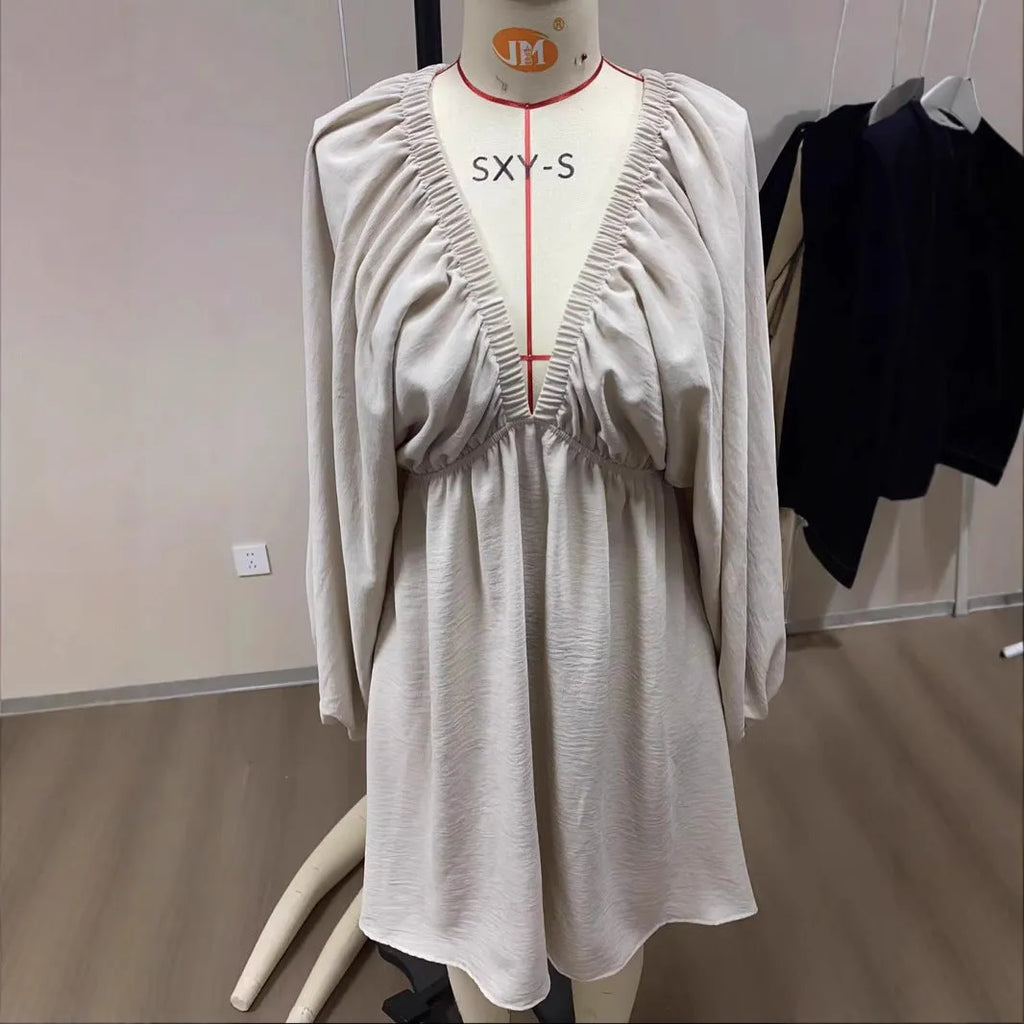 Solid colour V-neck dress with long puff sleeves and a mid-waist swing skirt.