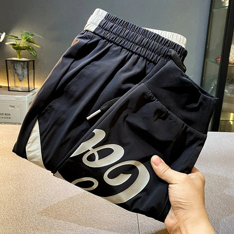 Men's black ultra-thin ice silk ankle banded casual trousers showing cropped design with elastic cuffs