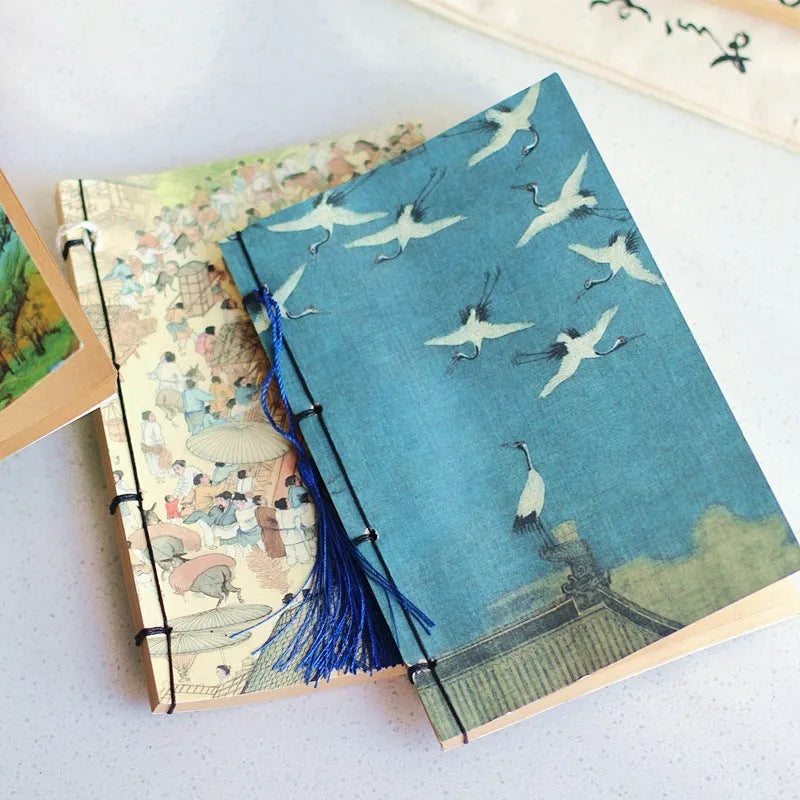Antique wire-bound notebook with historical artwork cover and decorative tassels