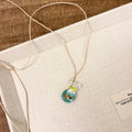 Women's coloured glaze pendant necklace on a beige cotton-linen cord, showing Skirt and Joker design details.