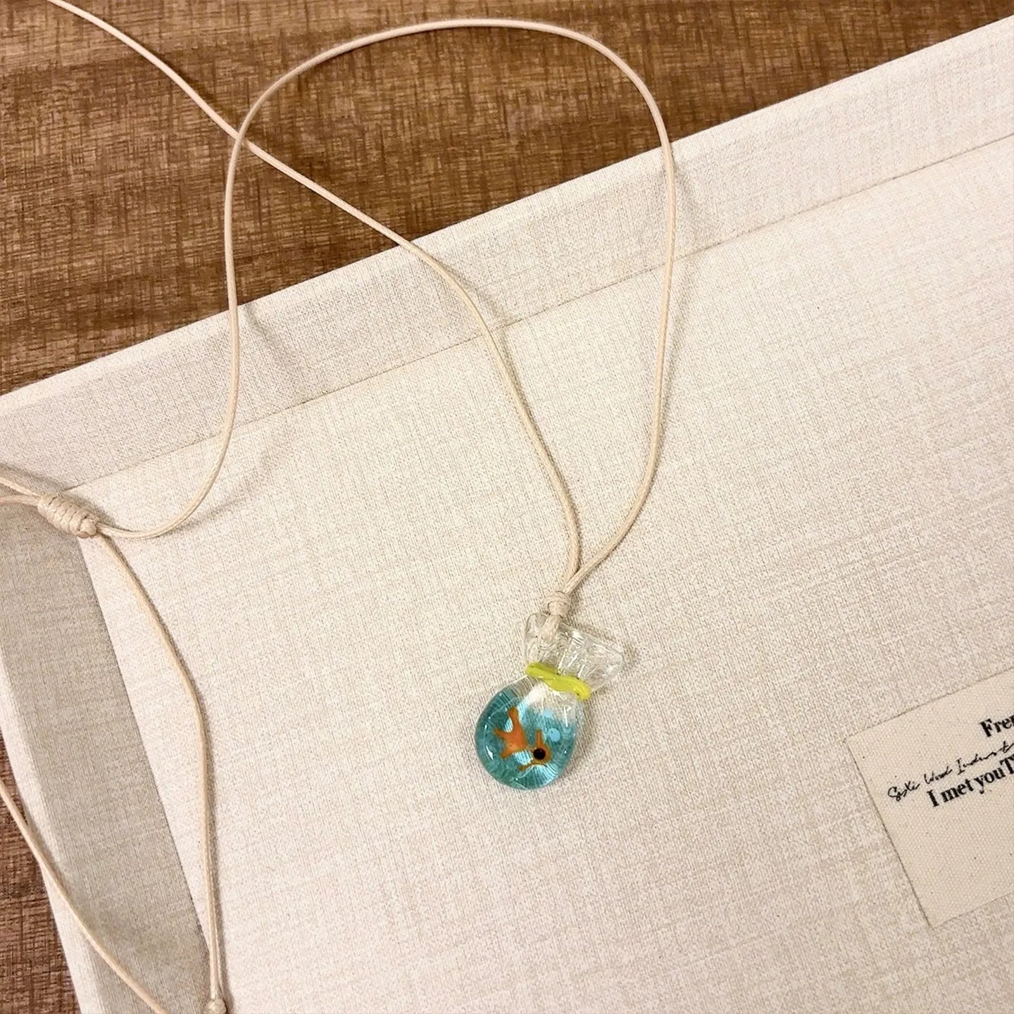 Women's coloured glaze pendant necklace on a beige cotton-linen cord, showing Skirt and Joker design details.