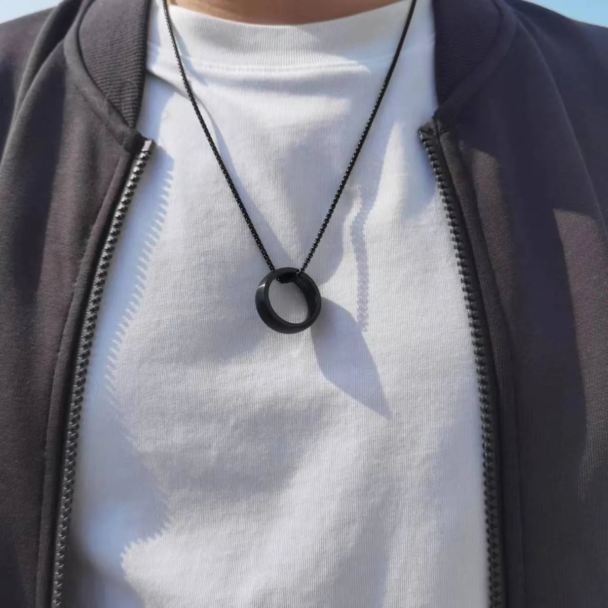 Men's silver stainless steel pearl chain necklace with titanium steel circle pendant on grey background