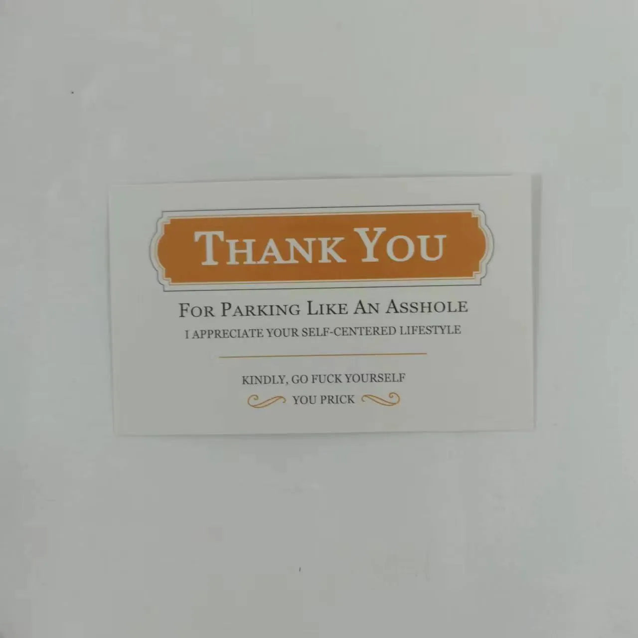 Box of paper illegal parking reminder cards featuring a printed middle finger design.
