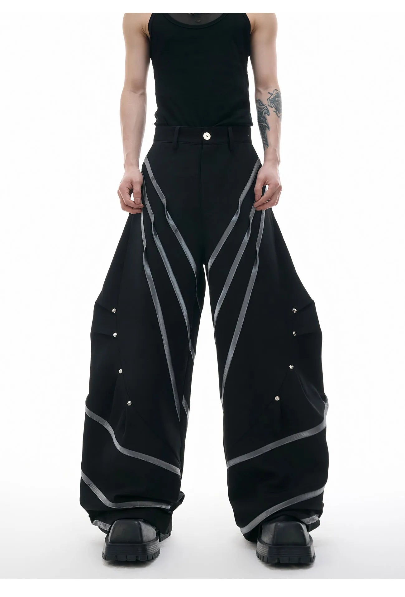 Men's black trousers with metal striped rivet and pleated detail on a three-dimensional cut.