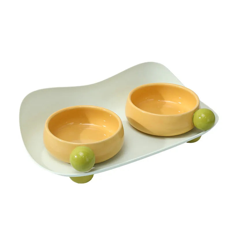 Ceramic raised pet feeding bowl set with two bowls and non-slip silicone supports in yellow colour