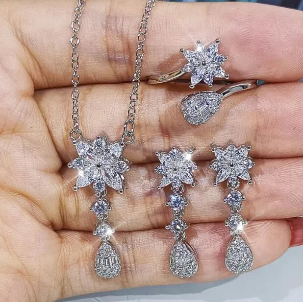 Floral zircon bridal jewellery set including ring, necklace with curb chain, and earrings on brass