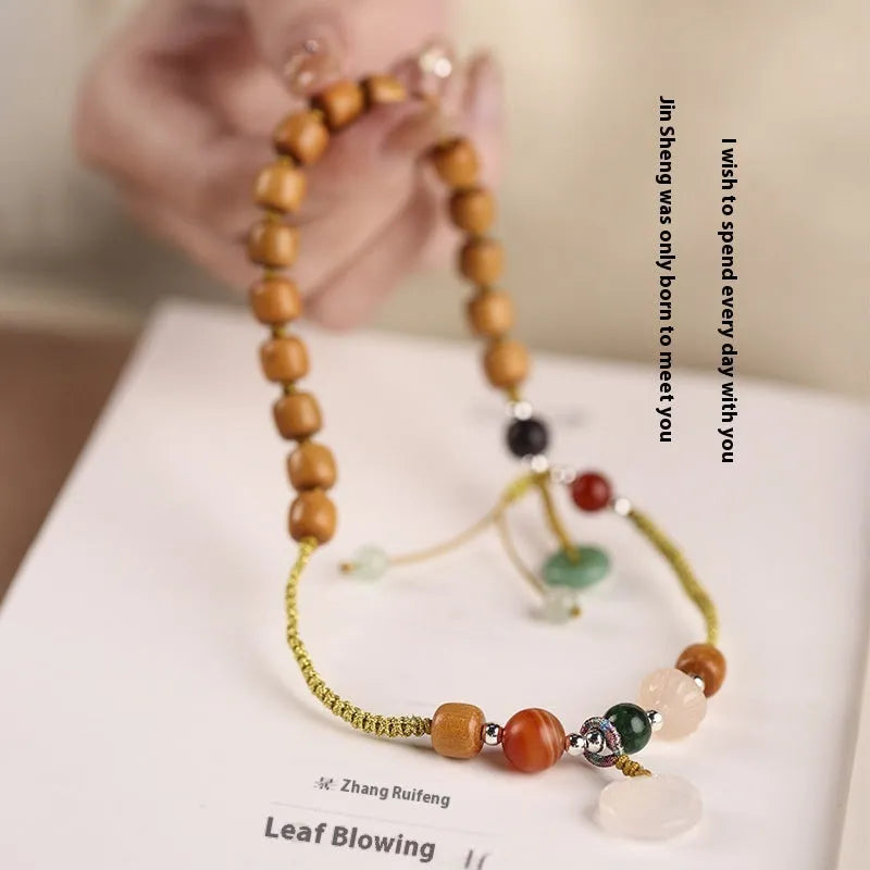 Hand-woven women's sandalwood bracelet with double-ring design and traditional gemstone accents