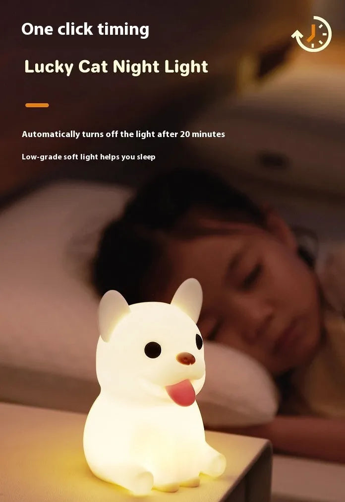 Soft silicone animal or cartoon-themed USB night light with dimming function on a bedside table.