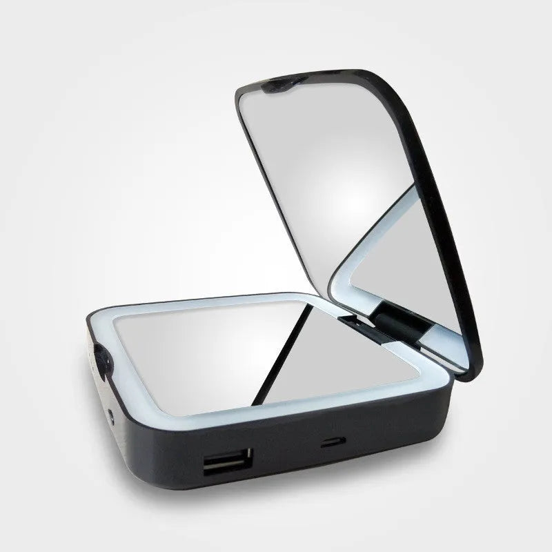 Black and white makeup mirror on table showing magnified and regular mirrors with illuminated ring light
