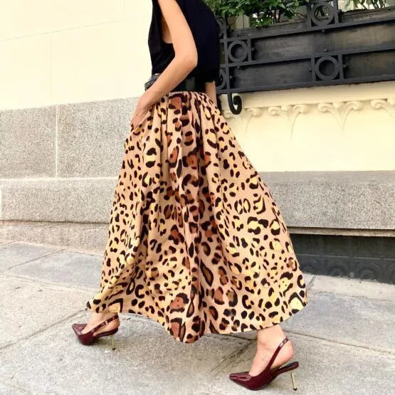 Brown leopard print women's long A-line skirt with a defined waist and wide, flowing hem on a neutral background.