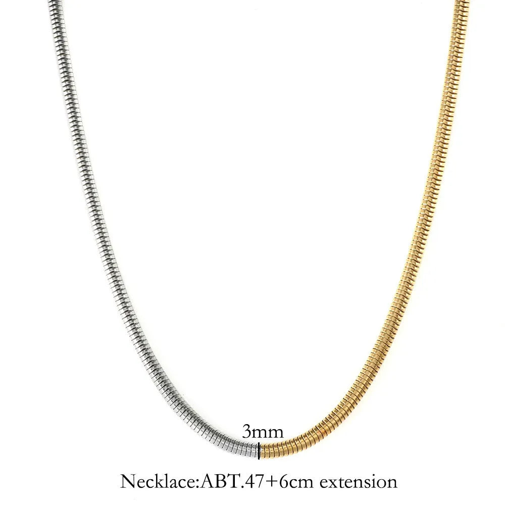 Gold-coloured snake bone chain necklace with geometric links on a white background.