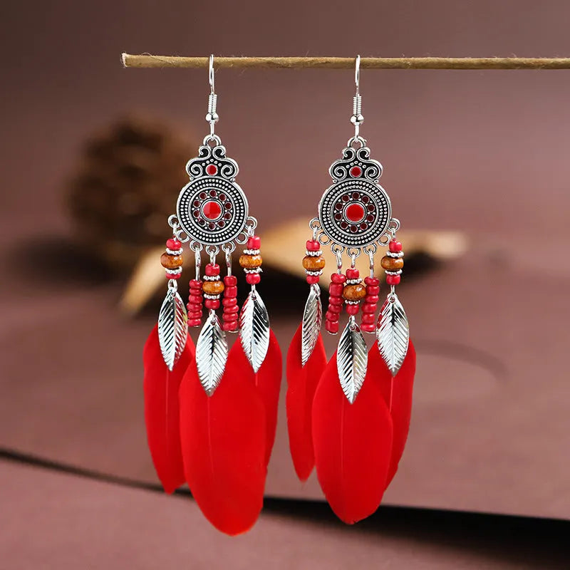 Round drop feather earrings in alloy with electroplated finish showing leaf shape and pattern details