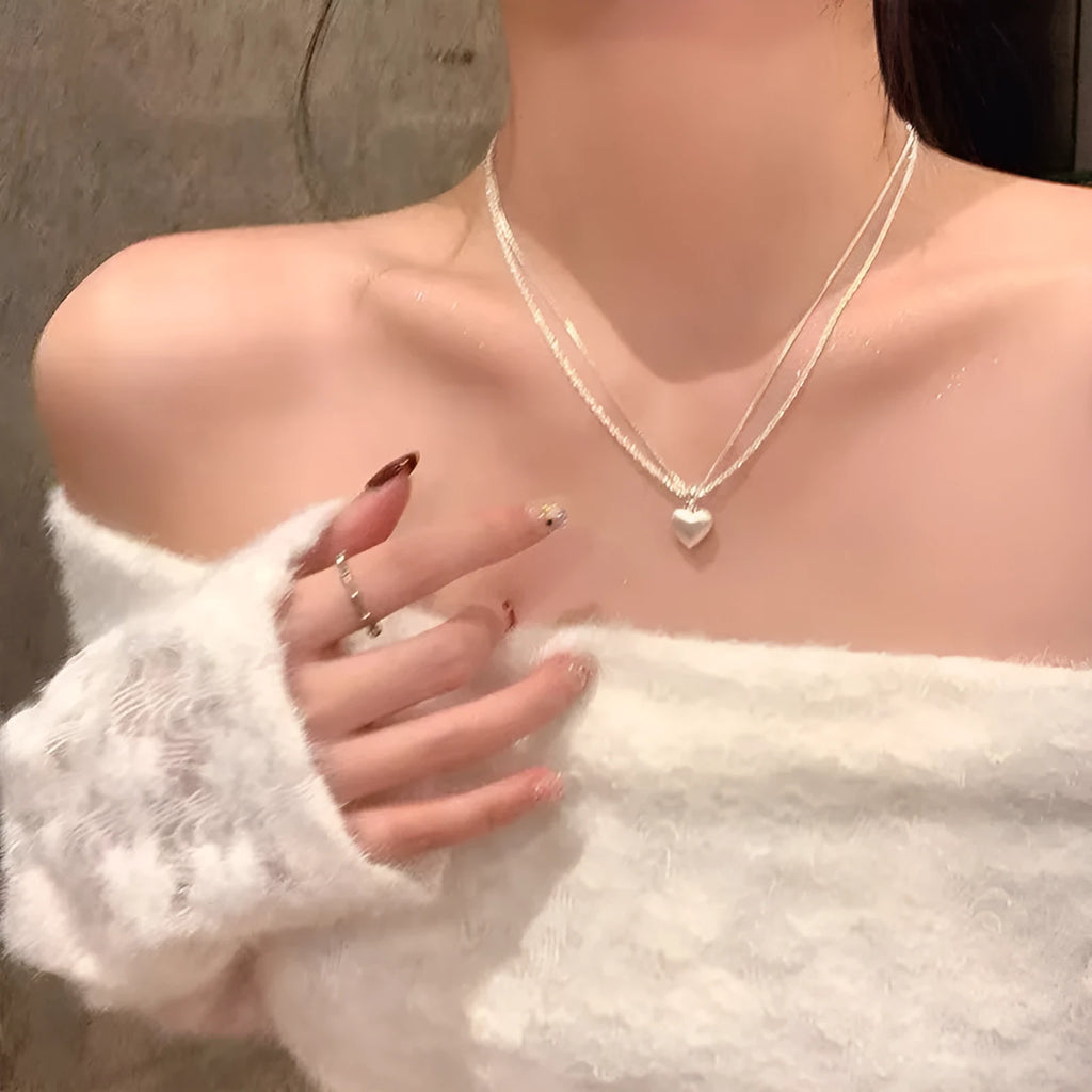 Double-layer brushed heart necklace with adjustable chain on white background