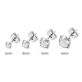 Simple geometric stud earrings with zircon stone in gold or steel colour on grey background.