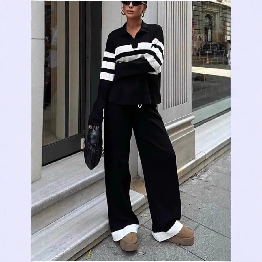 Woman wearing a black and white striped long-sleeve polo shirt and matching black casual trousers from a two-piece knit set.