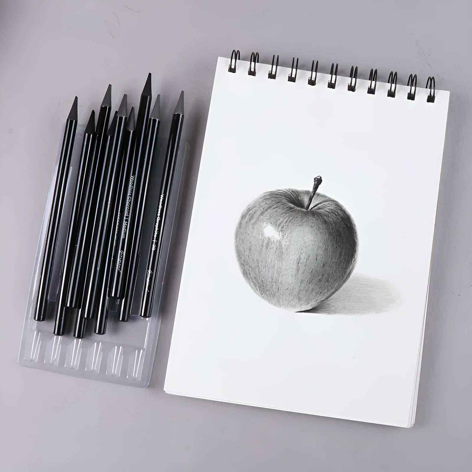Set of six graphite and three carbonized pencils with wooden casings on a retail suction card.