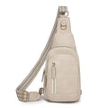 Soft brown women's crossbody chest bag with an open front pocket and decorative stitching.