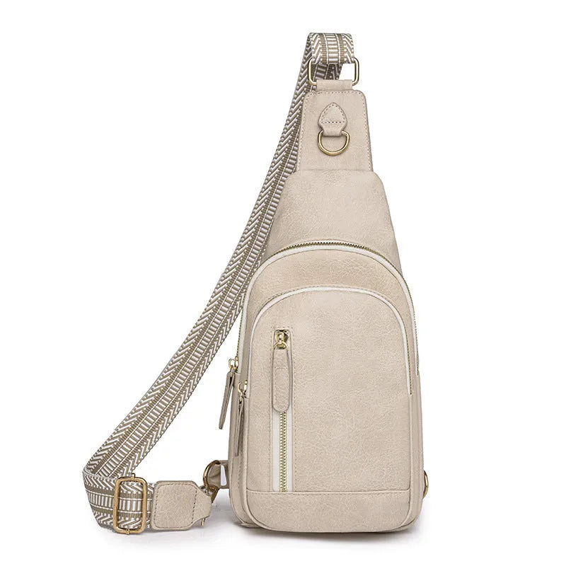 Soft brown women's crossbody chest bag with an open front pocket and decorative stitching.