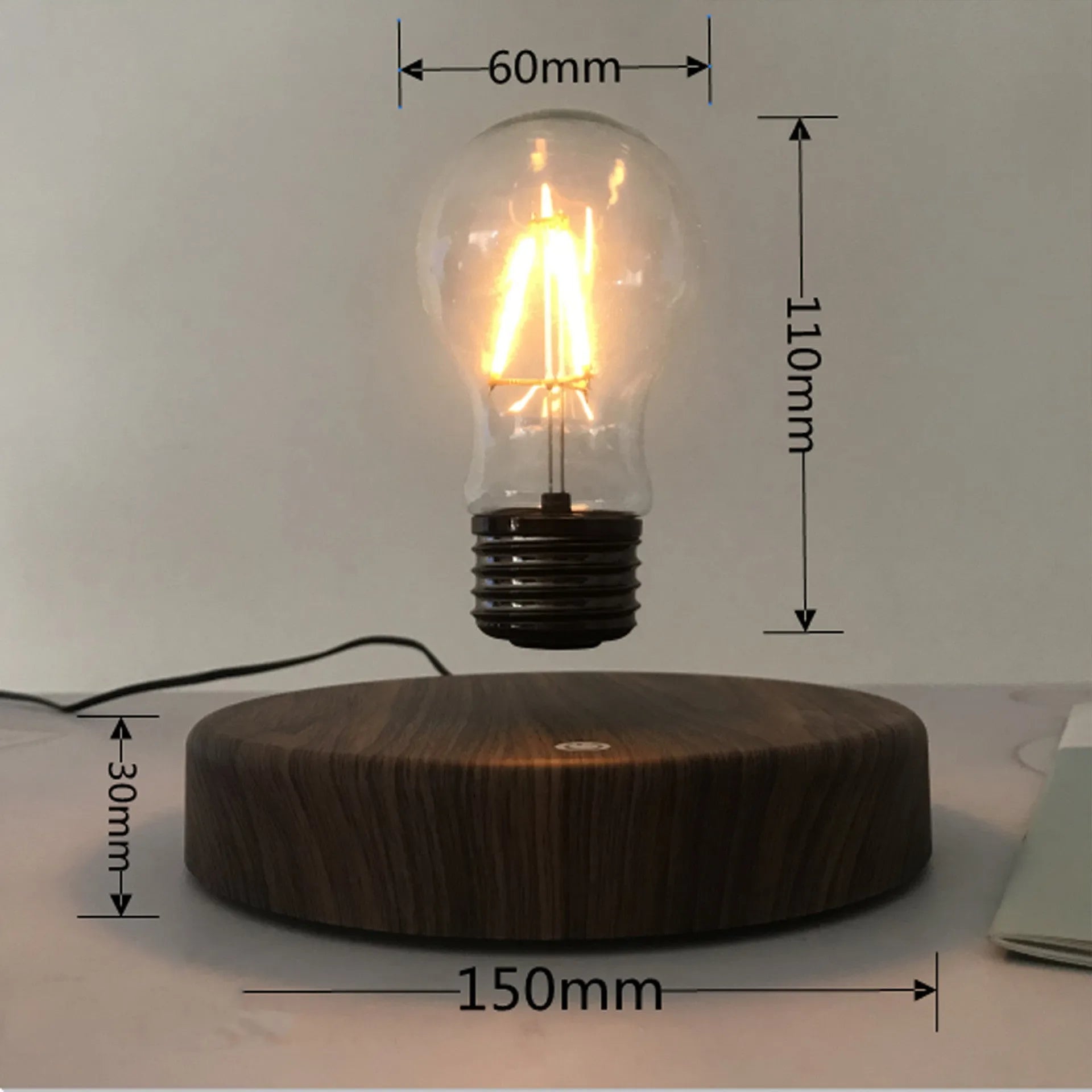 Magnetic levitation desk lamp with floating bulb on a solid wood colour base.