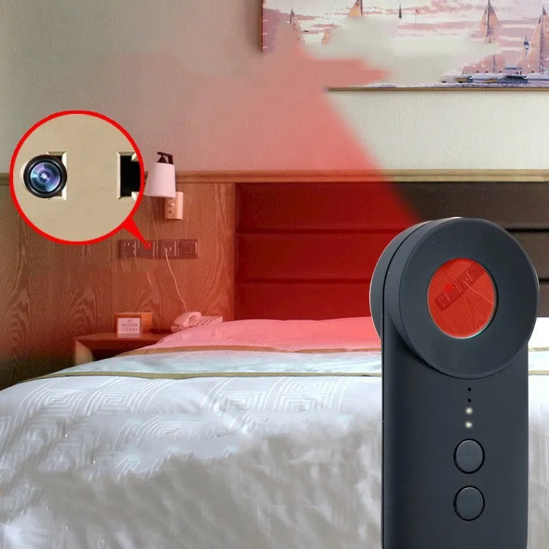 Black portable GPS and hidden camera detector with USB cable on a flat surface.