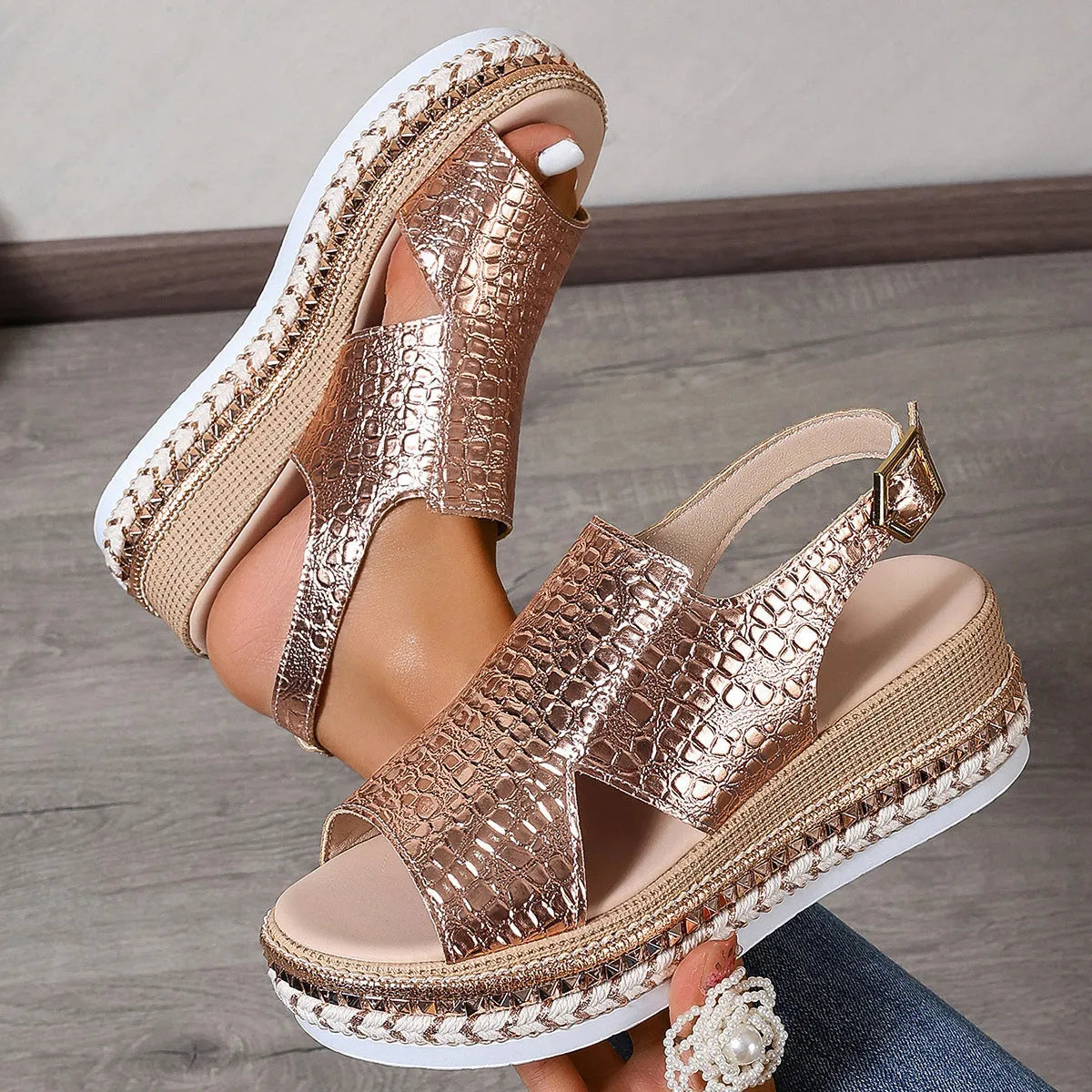 Gold women's Roman sandals with hollow-out design and an ankle buckle fastening.