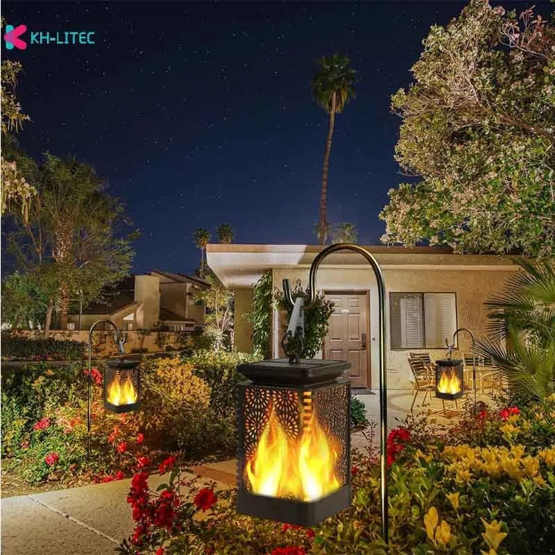 Set of four black solar-powered garden torch lights with flickering flame LED effect on a patio.
