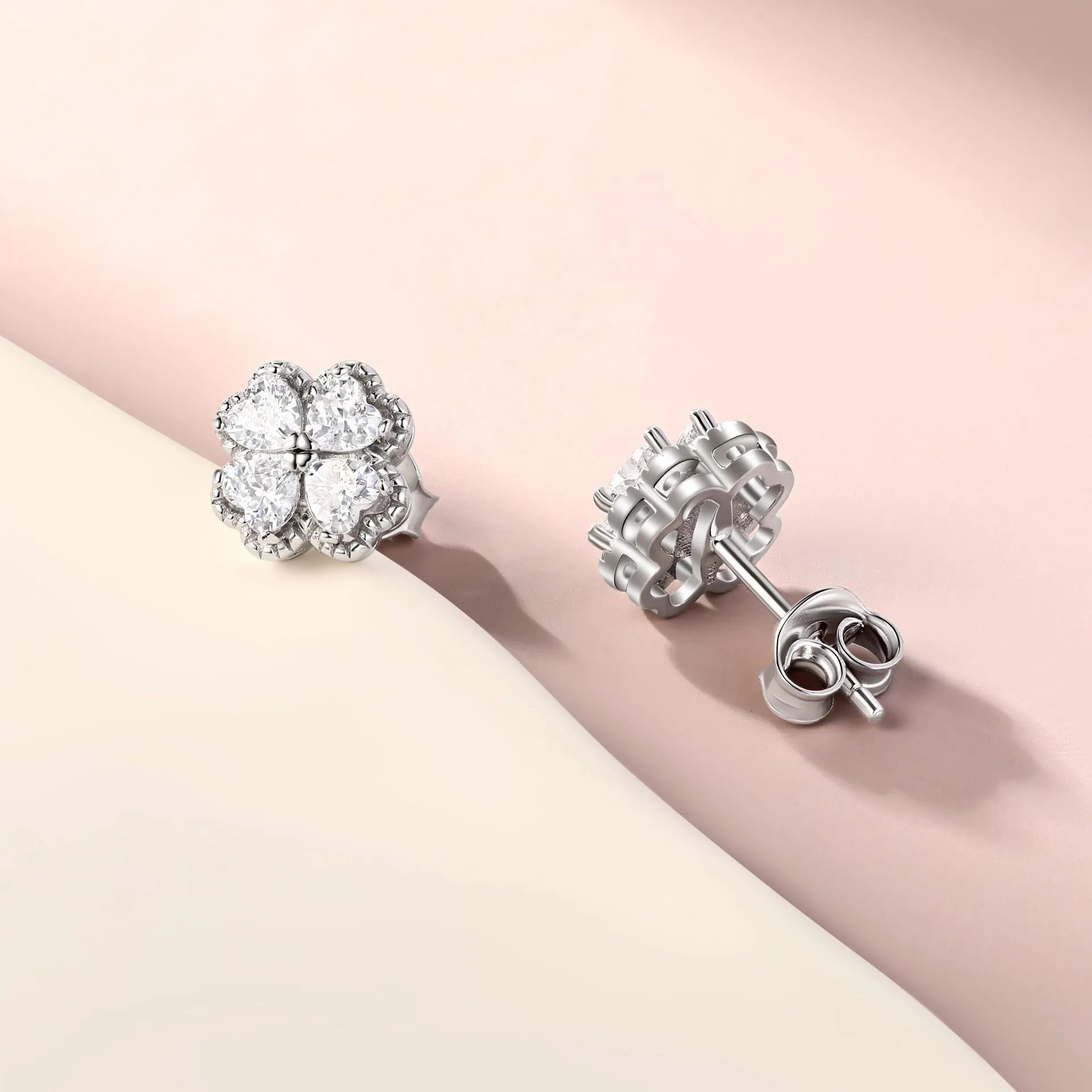 A pair of 925 silver four-leaf clover earrings with zircon stones in a heart-shaped setting.