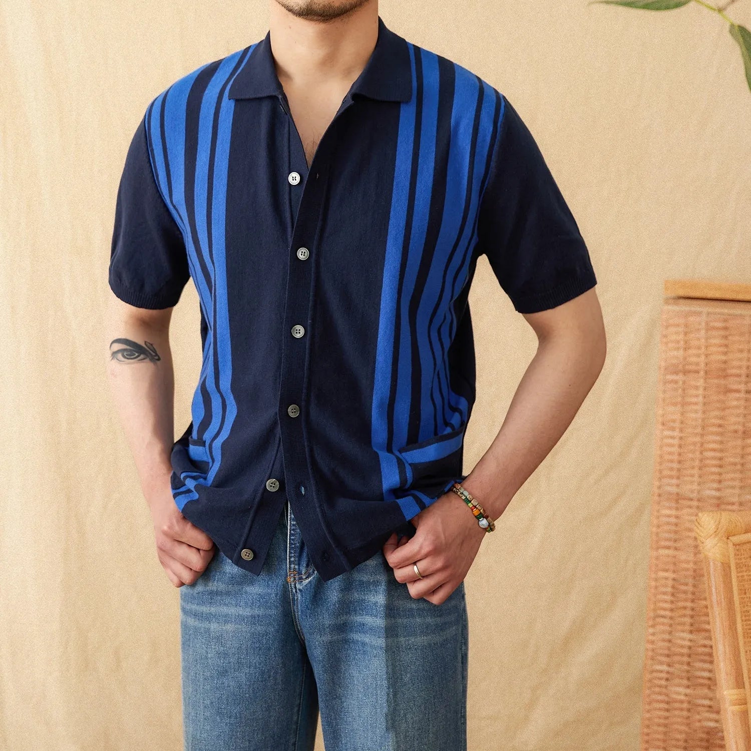 A royal blue striped lapel cardigan polo shirt on a hanger, showing short sleeves and knitted fabric.