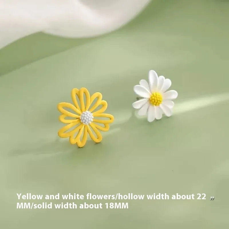 Close-up of colourful alloy flower stud earrings showing white and green two-tone design.