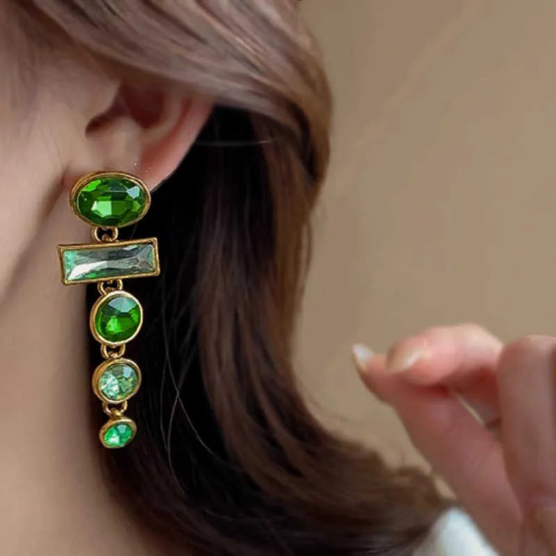 Pair of green gradient geometric ear studs with zircon details and a long tassel, on a white background.