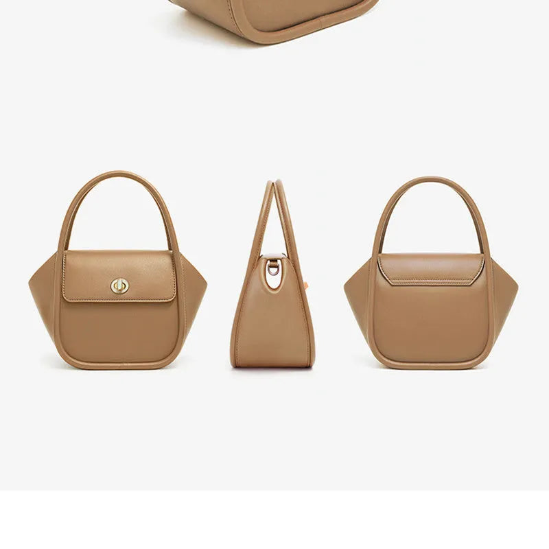 A women's leather wing-shaped tote bag with a metal latch, shown in blue on a cross-body strap.