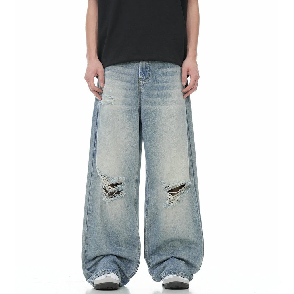 Men's blue straight-leg ripped jeans on a white background showing retro detailing and zip fly