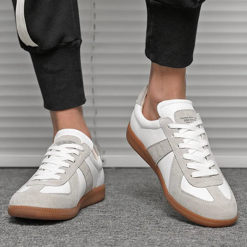 White Japanese-style retro low-top sneakers with round toe and flat rubber sole on a plain background.
