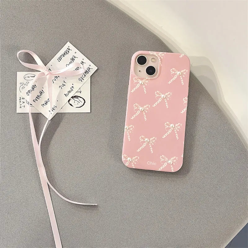 Pink soft TPU iPhone case with three-dimensional pearl dot bow, compatible with iPhone 11 to 15 Pro Max.