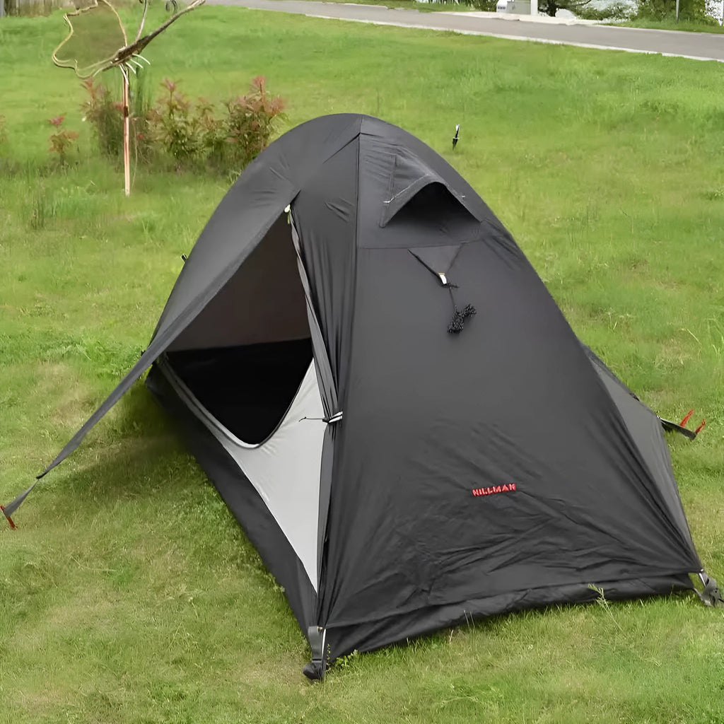 Single-person hiking tent in red pitched outdoors, showing aluminium poles and double-wall design with mesh inner.