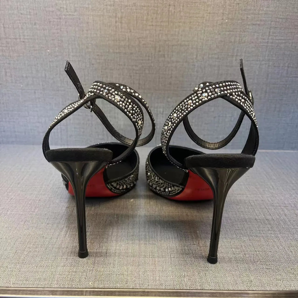 Women's black pointed-toe stiletto heels with a hollow-out design and red sole.
