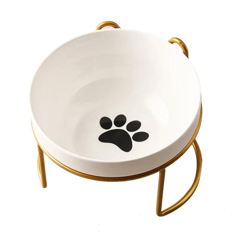 White ceramic cat bowl with cat footprint design on a black iron stand with cat ears.