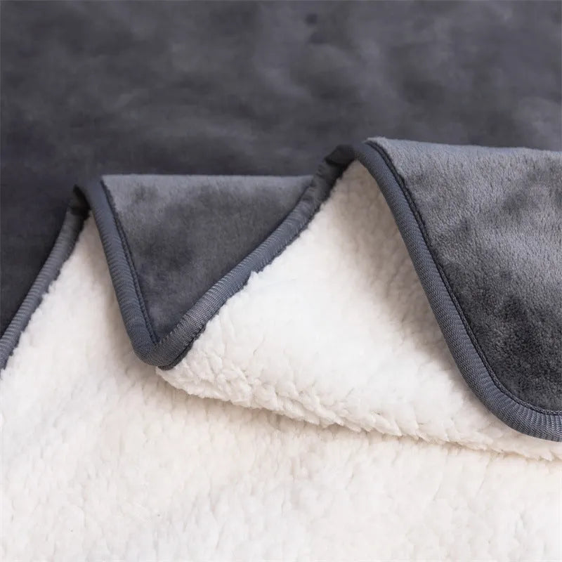 Grey lambswool waterproof dog blanket on a sofa, showing its cloth texture and size.