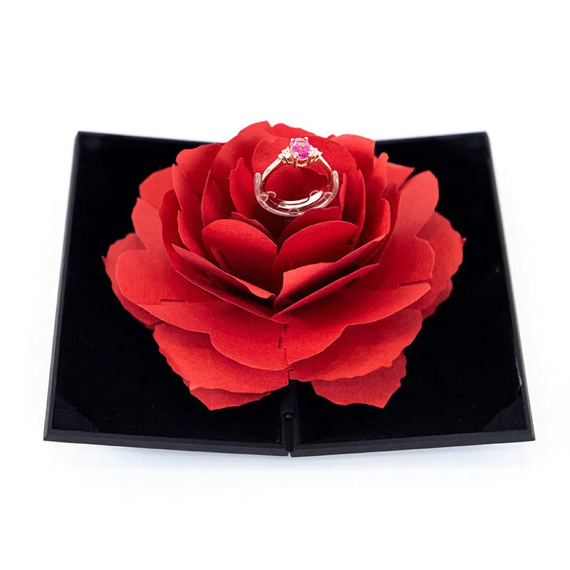 Red heart-shaped plastic ring box with a rose design and rotating 3D love text in the centre.