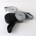 Three polyester cotton and latex silk resistance bands 200 x 4 cm in blue pink and purple on a flat surface