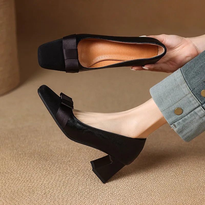 Retro square toe chunky heel pumps for women in black, with bow detail and low-cut design on a light background