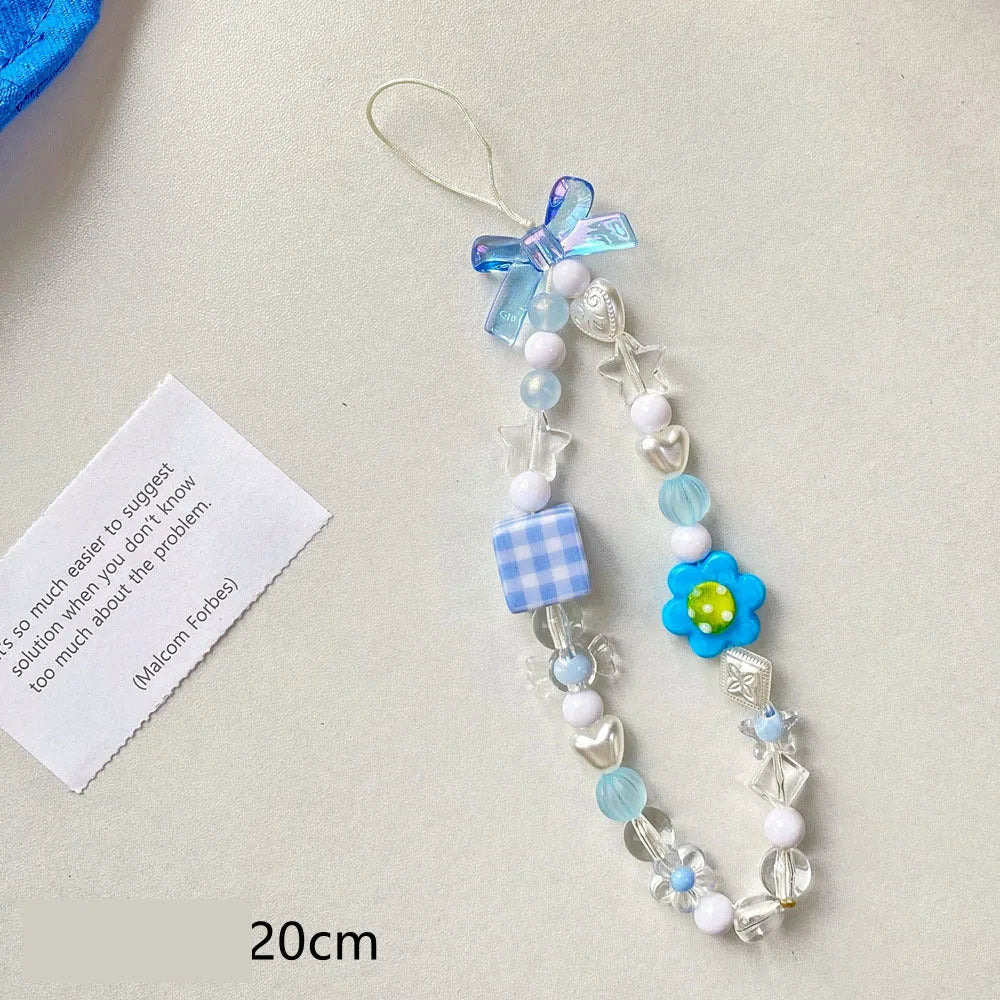 Colourful beaded flower lanyard for mobile phones with blue, pink, or yellow plastic flowers on an adjustable rope strap.