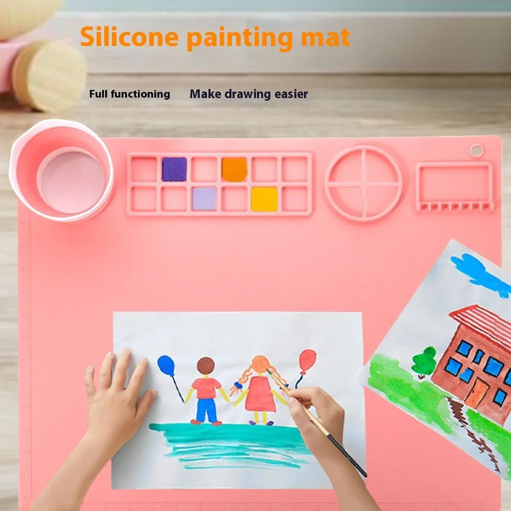 Light blue silicone painting mat measuring 50 by 40 cm on a wooden table