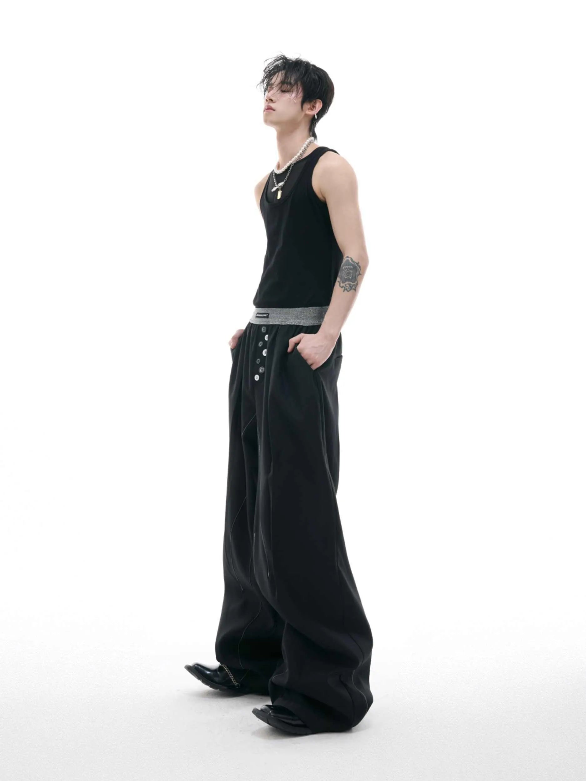 A pair of high-waisted straight-leg casual trousers in grey, showing the button-fly detail.