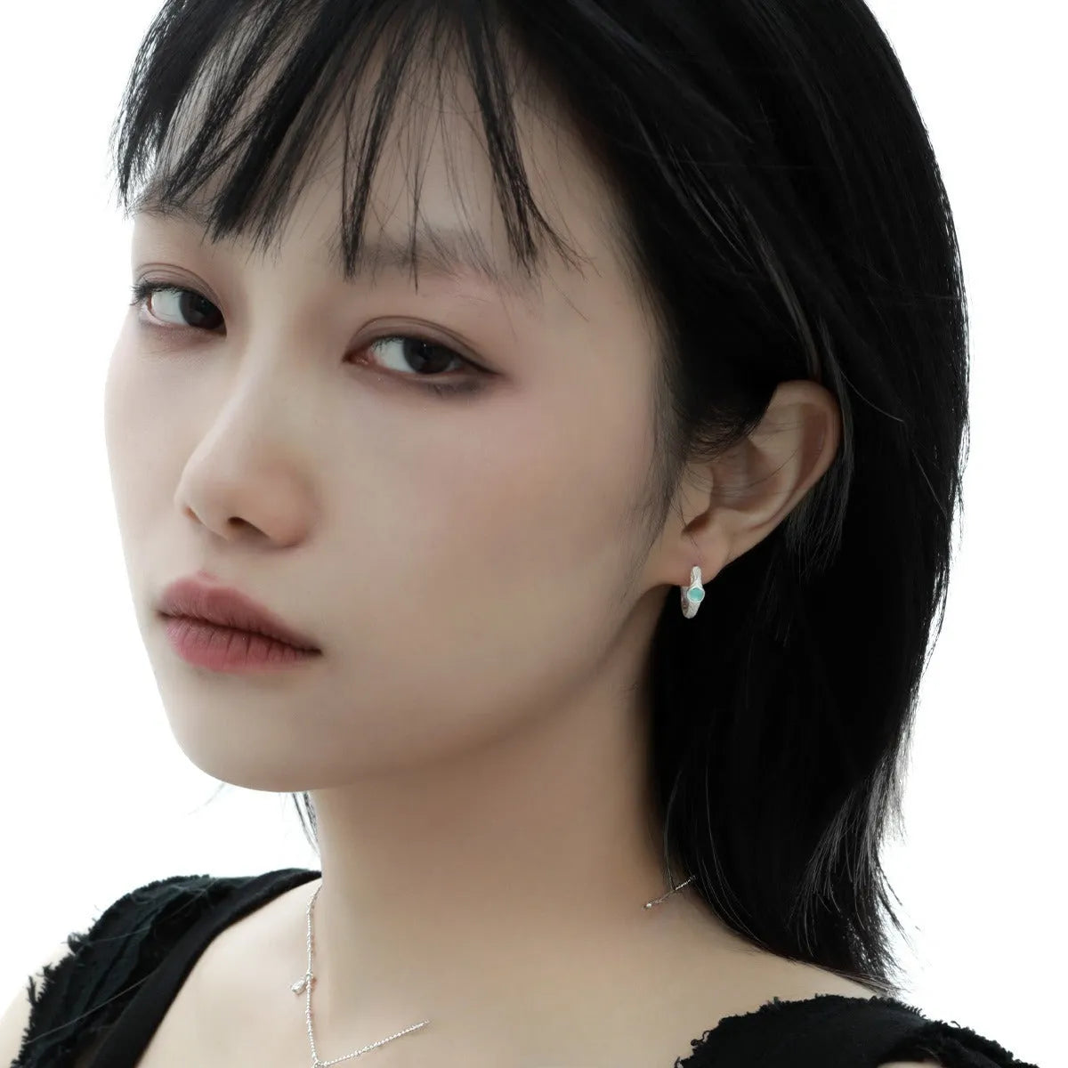Geometric round ear clips in burnt silver colour on a white background