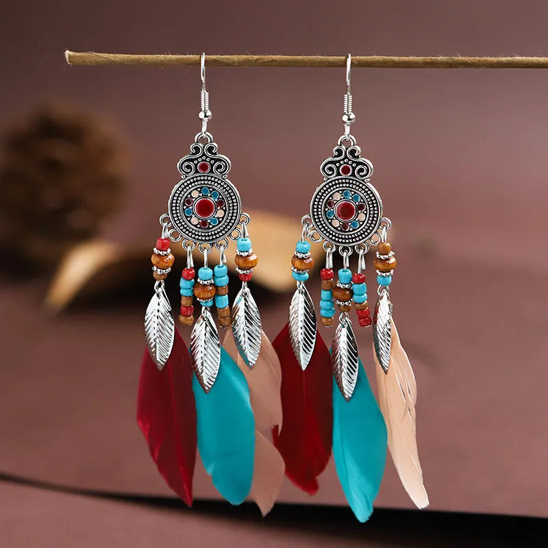 Round drop feather earrings in alloy with electroplated finish showing leaf shape and pattern details