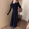 Dark grey knitted women's sweater and skirt set with a raised 3D pattern, laid flat.